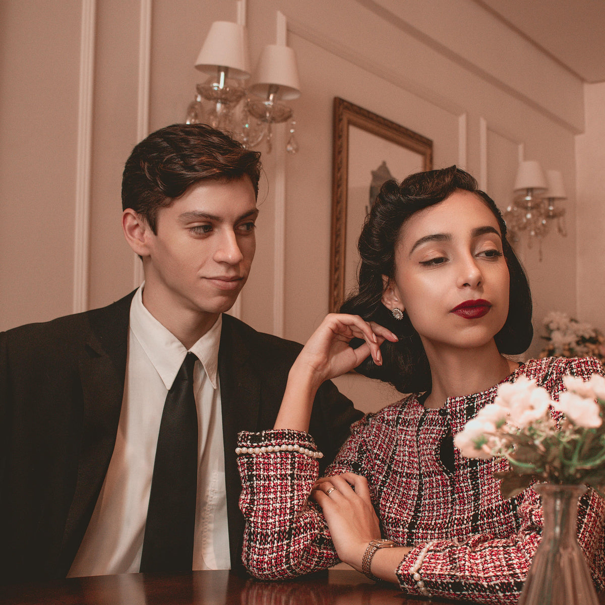 Modern man and woman in stylish new-season outfits from TAHMINA, standing in a luxury setting with strong lighting and confident poses