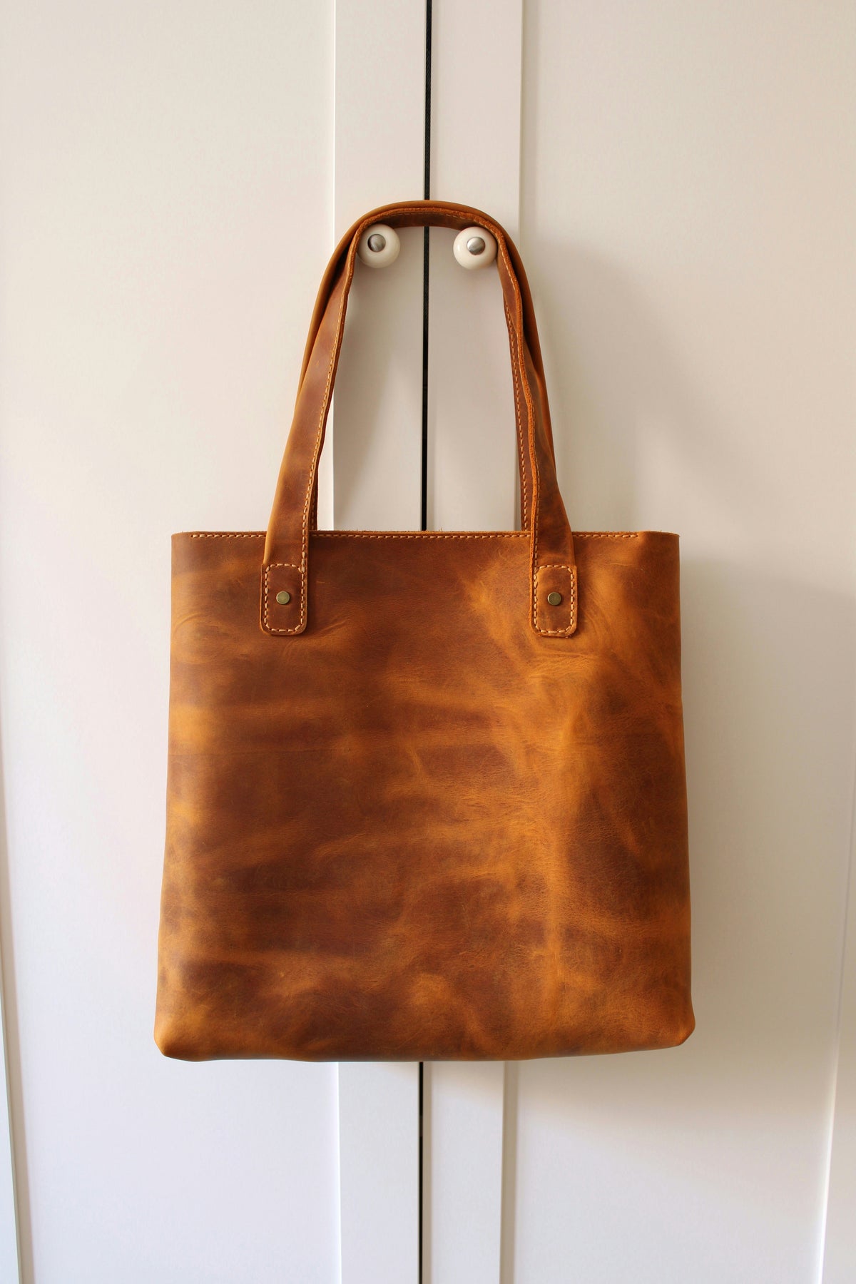 Designer leather bags displayed on a luxury surface, styled for TAHMINA’s American fashion collection